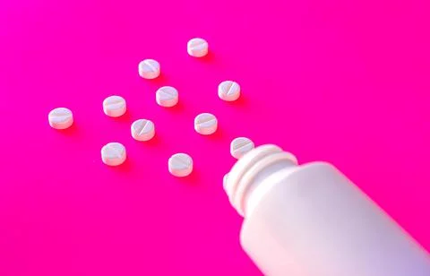 White tablets with package on pink background, medicine concept Stock Photos