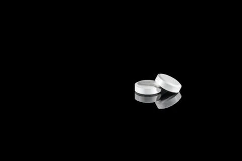 White tablets with reflection isolated on black background Stock Photos