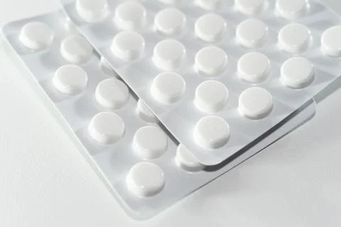 White tablets scattered on a white background Foto stock