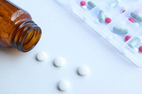 White tablets spilling out of packageany and Colorful tablets Stock Photos