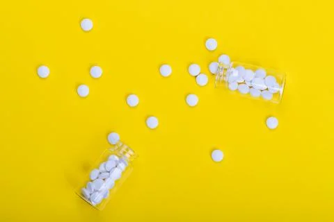 White tablets on the yellow background Stock Photos