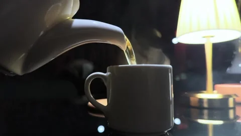 A white tea kettle is pouring water into a white coffee cup Stock Footage 282297906