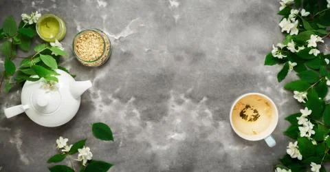 White tea pot, herbal dry tea, jasmin blossom, cup, black white marble backgr Fotos de archivo