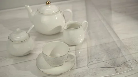 White Tea Set on Transparent Placemat on Light Wood Table Stock Footage 268114551