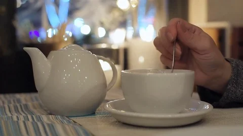 White teapot and cup on a  table  in city cafe. Stock Footage 84680042
