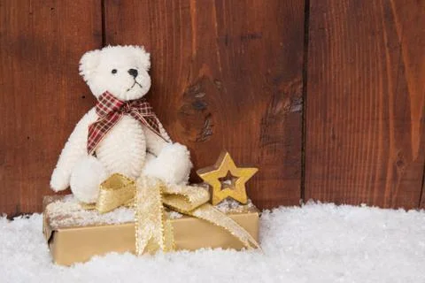 White teddy-bear sitting on present box for christmas Stock Photos
