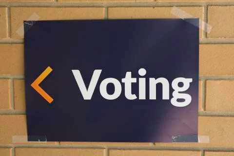 White text on blue background voting sign on brickwork with arrow Stock Photos