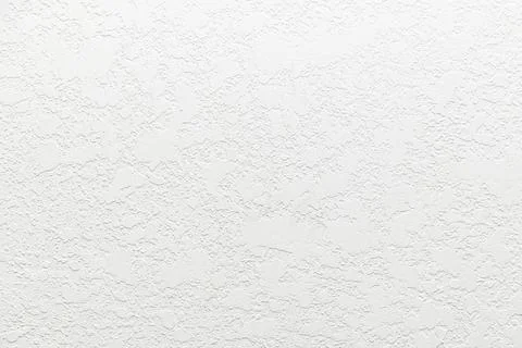 White textured wall surface with irregular raised plaster pattern Stock Photos