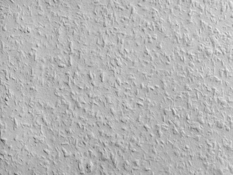 White textured wall surface. Light gray rough building texture. Stock Photos