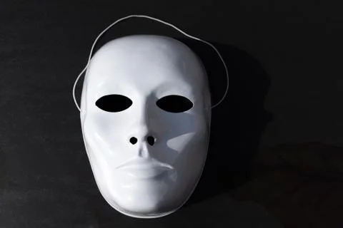 White theatrical mask on the black background Stock Photos