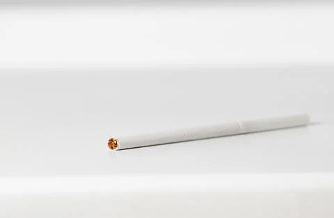White thin cigarette close-up on windowsill. Stock Photos