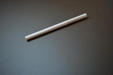 White thin cigarette with XS filter on matte brown background Stock Photos