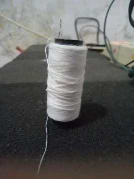 White thread and needle Stock Photos