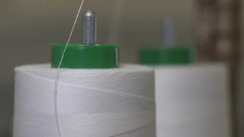 White thread coils on which unfolds the thin thread with which to sew a fabr Stock Footage 128724308