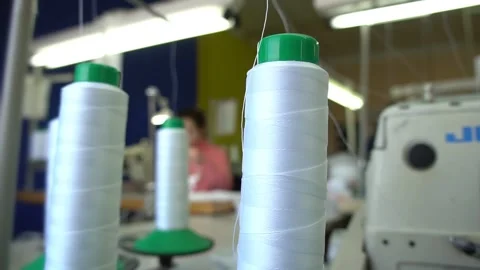 White thread on green metal spool moves to grey machine Stock Footage 136400550