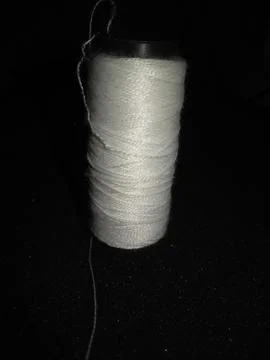 White thread with needle and black background Stock Photos