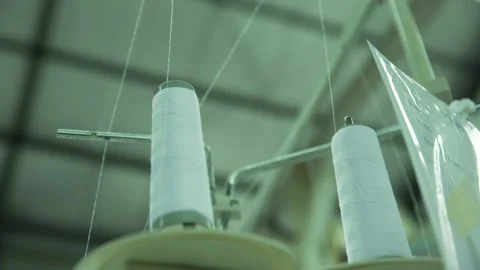 White thread spool with sewing machine in clothes factory Stock Footage 210165436