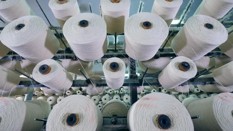 White threads on coils spinning on a factory machine. Video stock 114980372