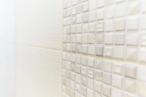 A white tile wall with a pattern of squares and triangles 写真素材