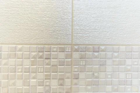 A white tile wall with a pattern of squares and triangles 스톡 사진