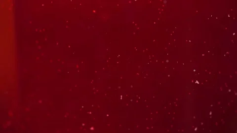 White tiny particles floating into bright red liquid 库存影片 301185583