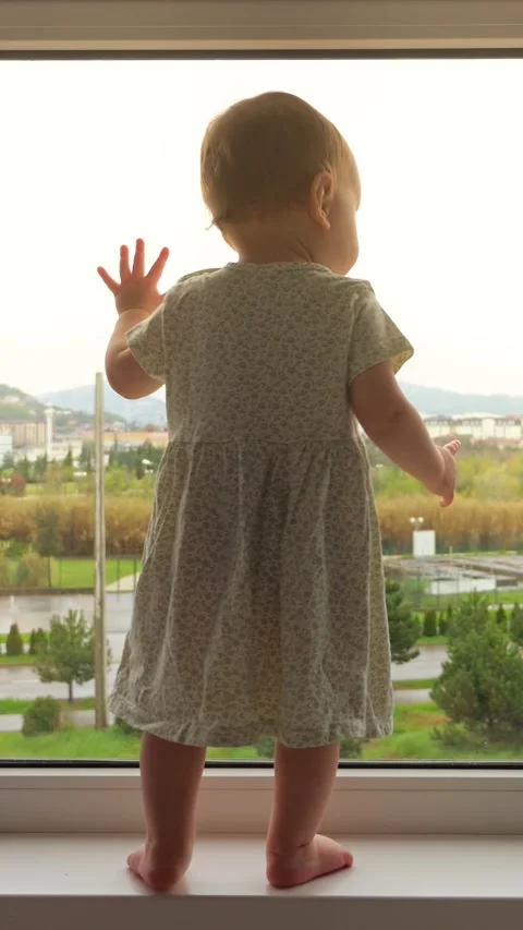 White Toddler Standing At Window Exploring City View, Tiny Hands Pressed Against Stock Footage 333892555