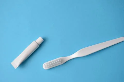White toothbrush and toothpaste. Blue background. Stock Photos
