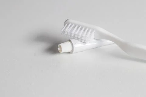 White toothbrush, tube of toothpaste. Stock Photos