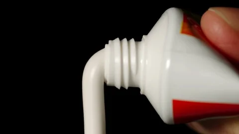 White toothpaste is squeezed from tube - Front View Stock Footage 104022800