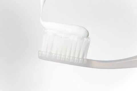 White toothpaste on the toothbrush bright closeup. Stock Photos