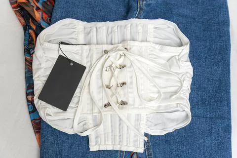 White top with lacing and empty black label. Branding mock up. Corset on jean 스톡 사진