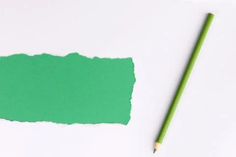 White torn paper over green background with pencil Stock Photos