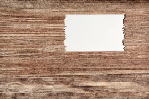 White torn off paper sheet on brown wooden wall with empty space for text. Illustrazione stock