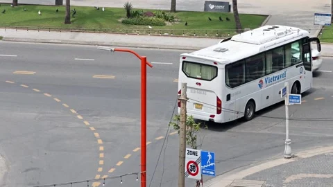 White tour bus driving through an urban intersection Video stock 310559203