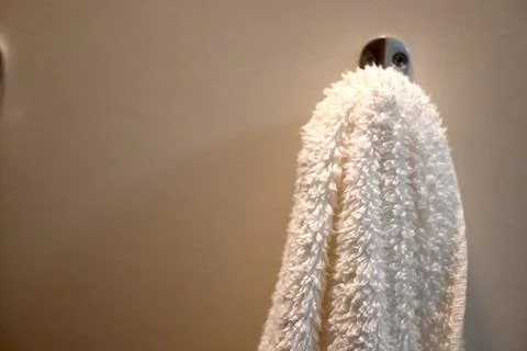 White towel hanging from a wall hook Stockfoto's