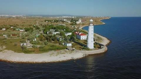 White tower of beacon is on sea shore at summer Stock Footage 299680614