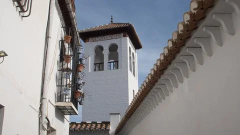 White tower of Muslim origin with two arched windows in the city of Granada. Stock Photos