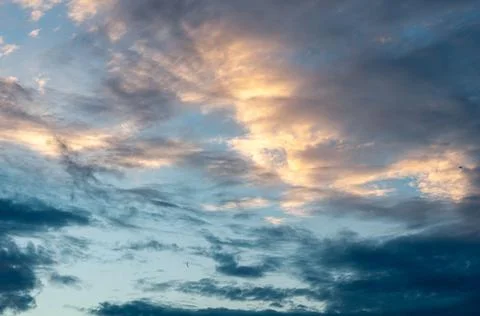 White translucent feathery clouds, reflections warm rays setting sun. Bright  Stock Photos