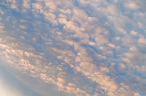 White translucent feathery clouds, reflections warm rays setting sun. Bright  Stock Photos
