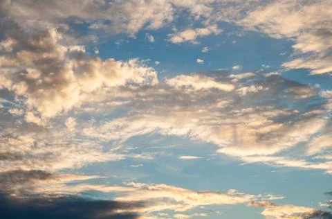 White translucent feathery clouds, reflections warm rays setting sun. Bright  Stock Photos