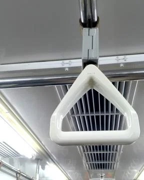 White triangular hand strap hanging on a train handle bar Photos