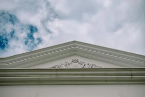 White triangular pediment with ornate details 스톡 사진