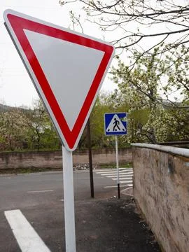 White triangular yield road sign with a pedestrian crosswalk sign Stock Photos