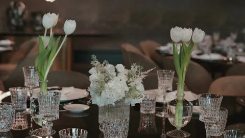 White tulip flowers decorating elegant event dining table Stock Footage 345861284