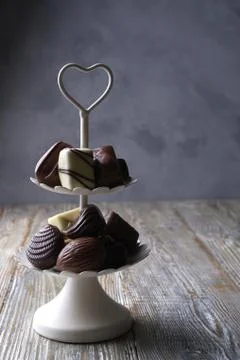 White two tier serving tray full of sweet confectionery with chocolates Fotos de archivo