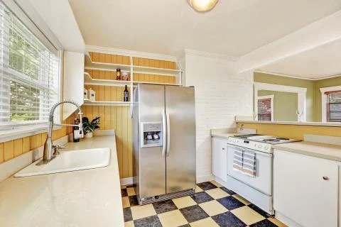 White U-shaped kitchen room interior with modern stainless steel refrigerator.  Fotos de archivo