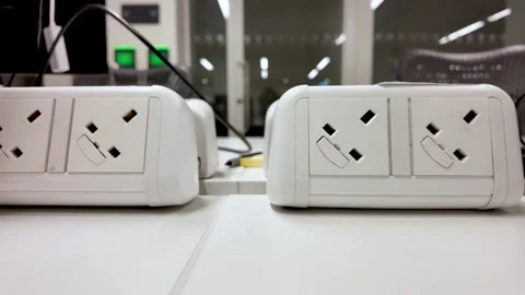 White UK Style Plug Sockets On Office Table For Powering Devices And Charging Stock Footage 325838945