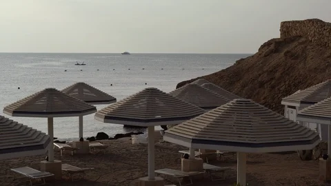 White umbrellas on the beach on the coast of the Red Sea In Sharm El Sheikh, Stock Footage 100842032