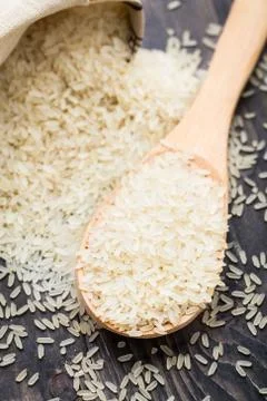 White uncooked rice in a spoon Stock Photos