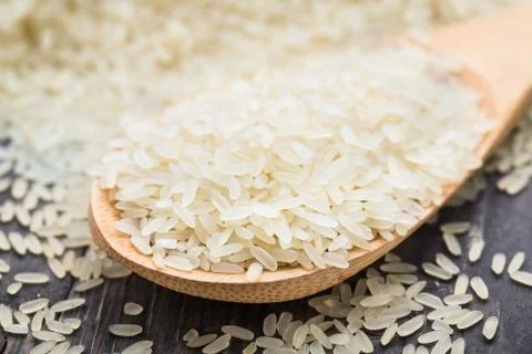 White uncooked rice in a spoon Stock Photos